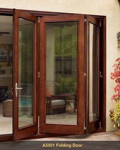 an open patio door with glass panels and wood trimmings on the outside wall