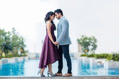 a man and woman standing next to each other near a pool