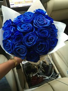 a bouquet of blue roses sitting in the back seat of a car