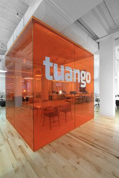 an office with orange glass partitions and wooden flooring that says tuango