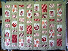 a quilted wall hanging with red and white designs on it's sides,