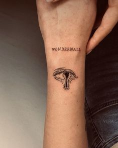 a woman's arm with a tattoo on it that reads wonderwall and an image of a snake