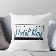 she kept the hotel key throw pillow on a couch with grey pillows and white walls