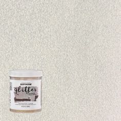 a can of glitter paint sitting on top of a white counter next to a wall