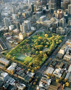 an aerial view of a large city with lots of tall buildings and trees in the foreground