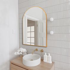 a bathroom sink sitting under a mirror on top of a wooden counter next to a white wall