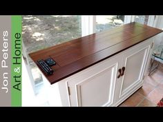 a kitchen island with a remote control on it's top and an open window behind it