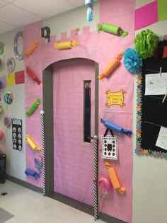 a classroom decorated with pink walls and lots of colorful items on the door to it