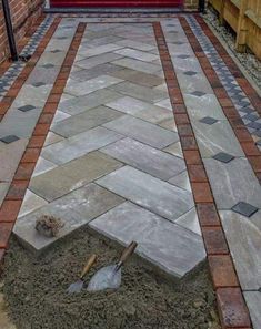 an outdoor patio with brick pavers and flagstone walkway leading up to the front door