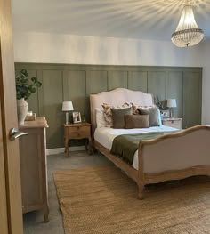 a bed room with a neatly made bed and a chandelier hanging from the ceiling