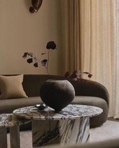 a living room with marble tables and couches