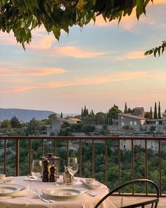 an outdoor dining area with table and chairs overlooking the city at sunset or dawn in italy