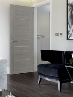 a living room with a black chair and white walls