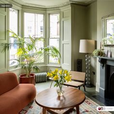 a living room filled with furniture and a fire place in front of a large window