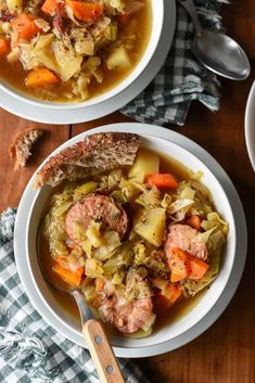 two white bowls filled with soup on top of a wooden table