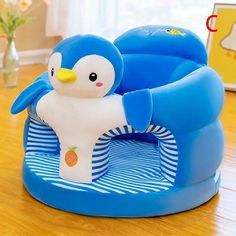 a blue and white penguin toy sitting on top of a wooden table