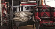 a living room filled with lots of different types of pillows and blankets on top of shelves