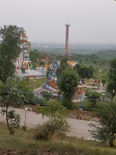 an amusement park with several rides and trees