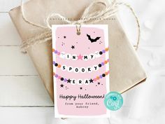 a gift tag that says happy halloween hanging from a twine of twine with a bat on it