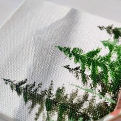 someone is painting trees on canvases with colored pencils