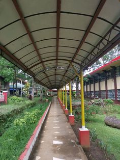 the walkway is lined with red and yellow poles, along with green plants on either side