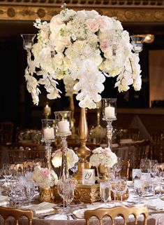 a table topped with lots of white flowers and candles