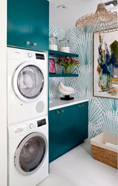 a washer and dryer in a room with blue wallpaper on the walls