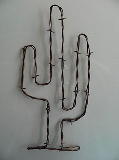 a metal cactus sculpture on a white wall