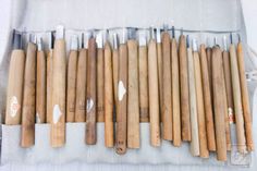 a bunch of baseball bats sitting on top of a white cloth covered table next to each other