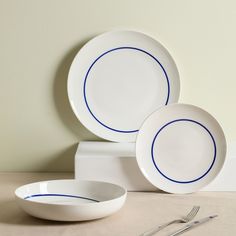 three white plates with blue lines on them