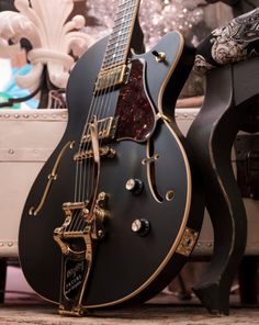 a black guitar sitting on top of a table