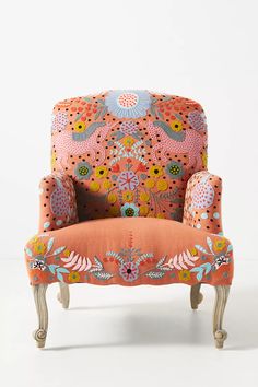 an upholstered chair with floral designs on the armrests and foot rest