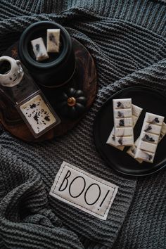 two black plates with cookies on them next to a cup and saucer filled with tea