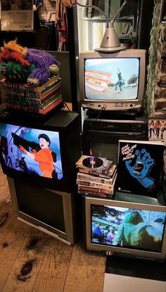 several televisions are stacked on top of each other in front of a pile of books