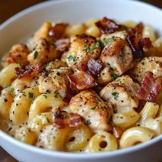 a white bowl filled with macaroni and cheese covered in bacon