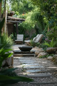 a stone path leads to an outdoor seating area with chairs and trees in the background