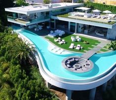 an aerial view of a house with a swimming pool and lounge chairs in the foreground