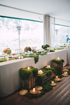 the table is covered with moss and lit candles