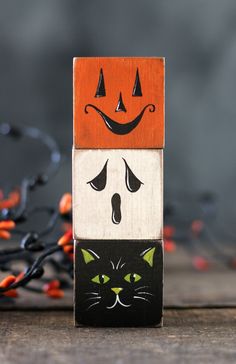 a wooden block with an image of a cat and a pumpkin on it's face