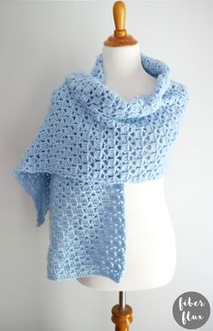 a crocheted shawl is shown on a mannequin