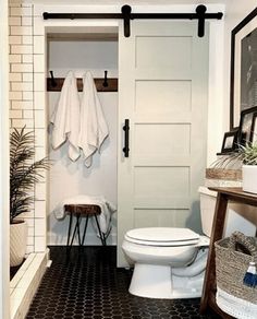 a white toilet sitting in a bathroom next to a wooden shelf with towels on it