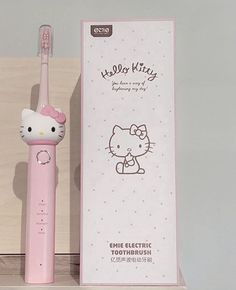 an electric toothbrush with hello kitty on it next to a cardboard box and packaging