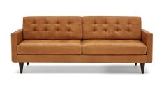 a tan leather couch sitting on top of a white floor