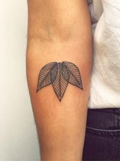 a woman's arm with a tattoo on it that has leaves in the middle