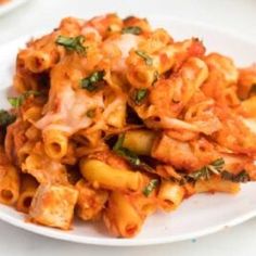 a white plate topped with pasta covered in sauce