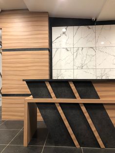 a marble and wood counter top in a room with tile flooring on the walls