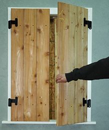 someone is holding their hand out to open the door with wood planks on it