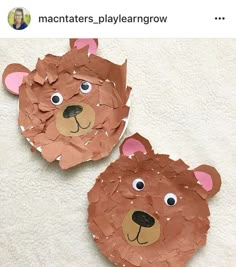 two brown bears made out of paper sitting on top of a white sheet of paper