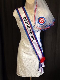 a mannequin wearing a white dress with a red and blue ribbon around the neck