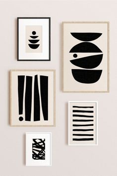 four black and white art pieces hanging on the wall next to each other in different frames